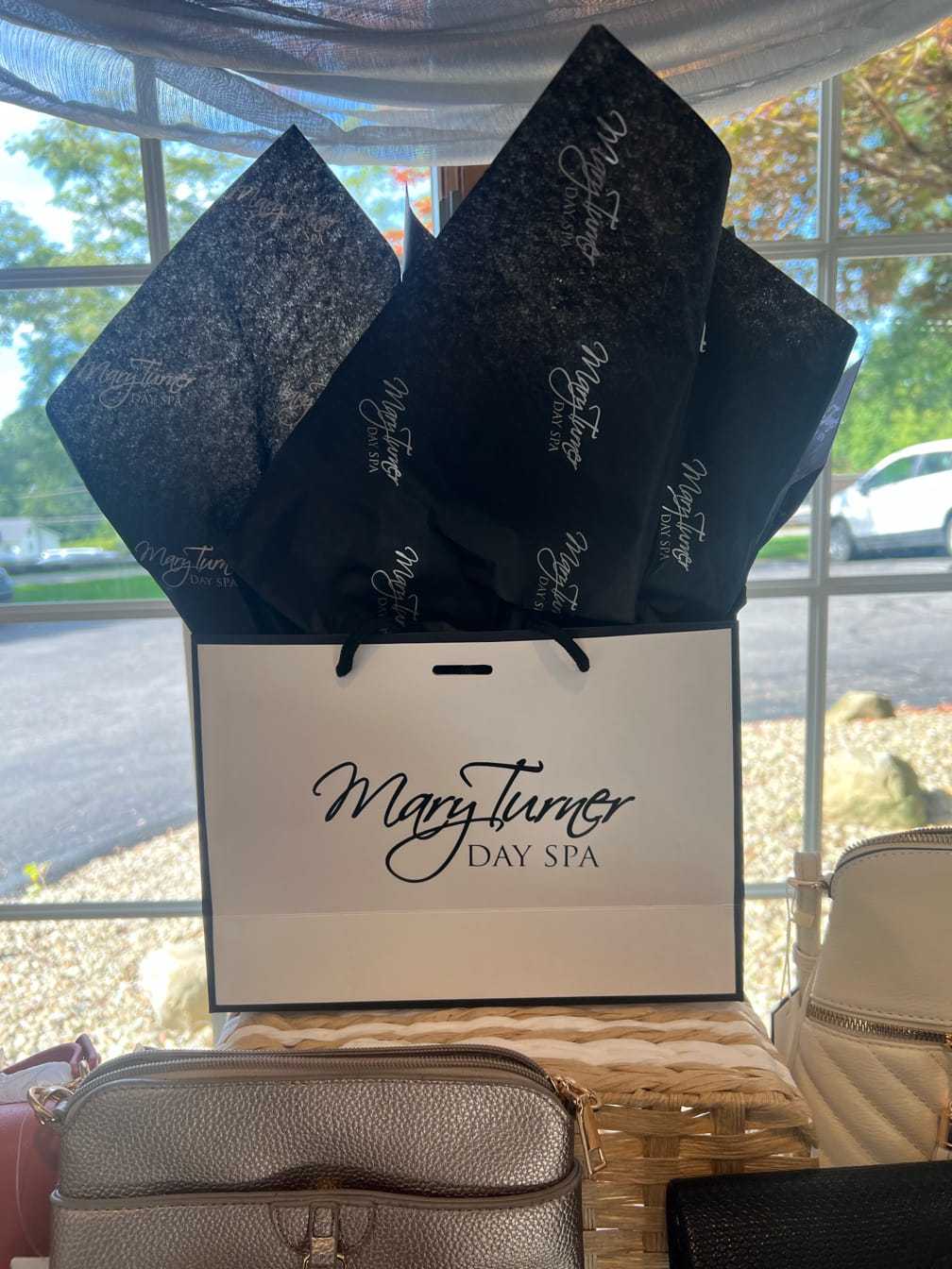 Mary Turner Day Spa gift bag with tissue paper, displayed in a bright room by the window.